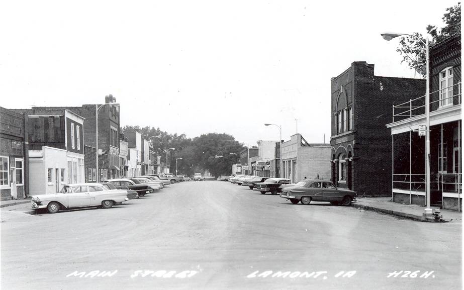 old black and white image of main st lined with cars